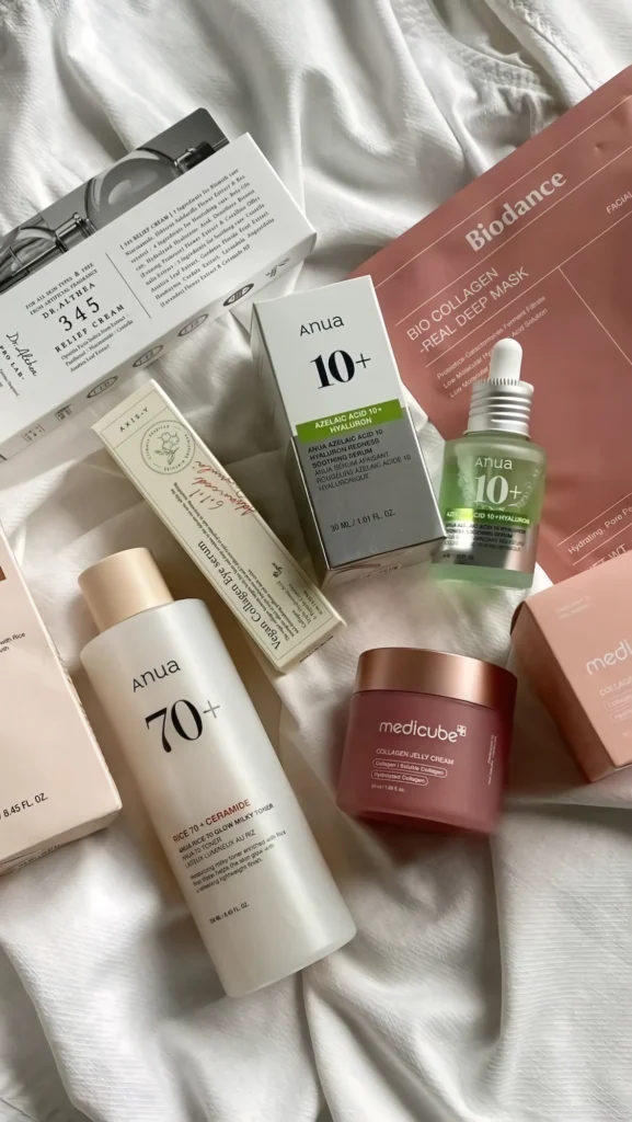 Soins Anua, Dr. Althea, Axis-Y, Biodance et Medicube posés sur un drap blanc